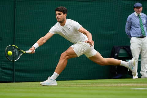 Carlos Alcaraz plays a forehand return to Tommy Paul